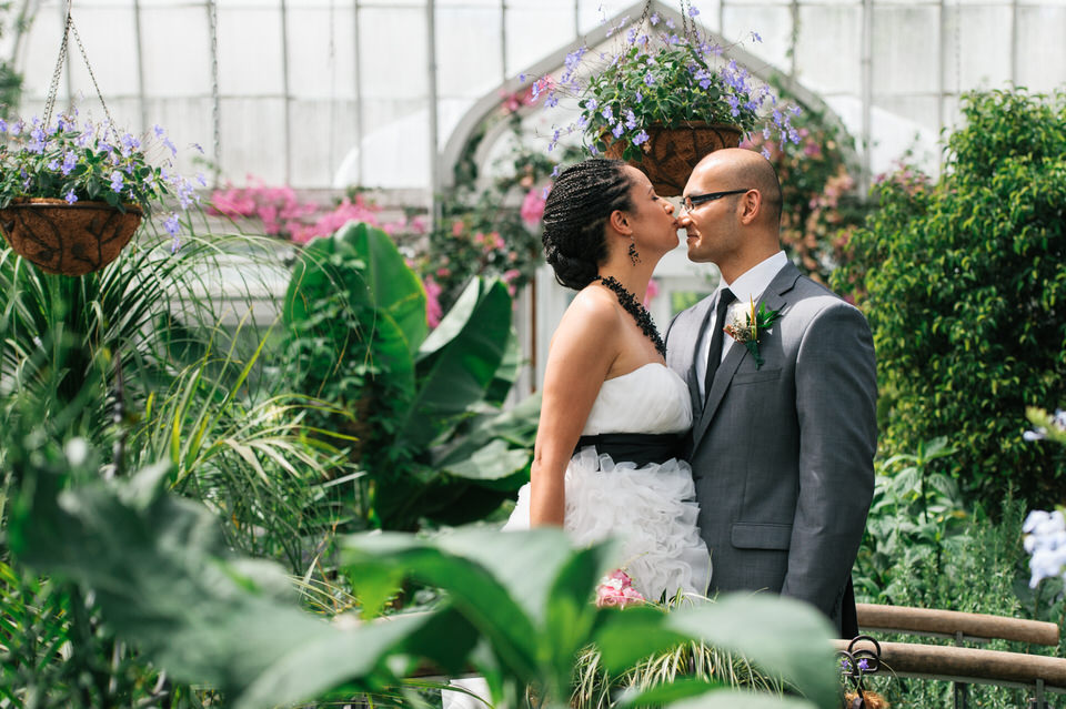 Mariée embrassant le nez de son époux entourée de verdure dans la serre Westmount