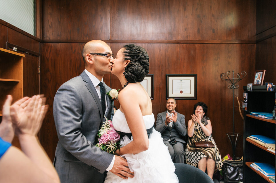 Nouveaux époux s'embrassant suite à la signature de leur acte de mariage chez la notaire