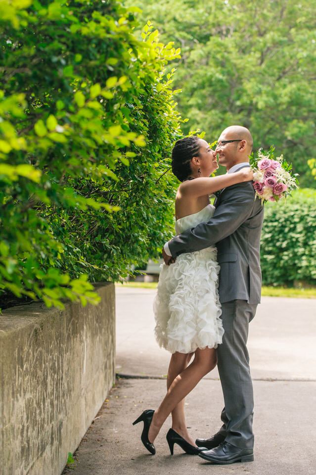 Femme jetant ses bras au tour du cou de son mari tout en tenant son bouquet