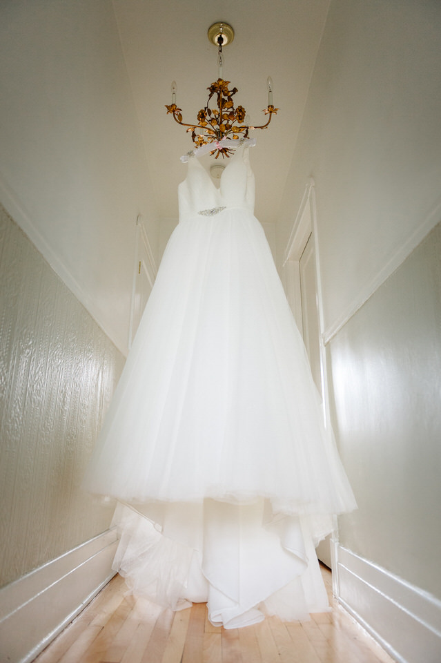  White wedding dress hanging from a vintage chandelier 