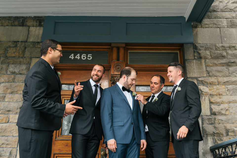 Groomsmen putting last minute touches on the groom