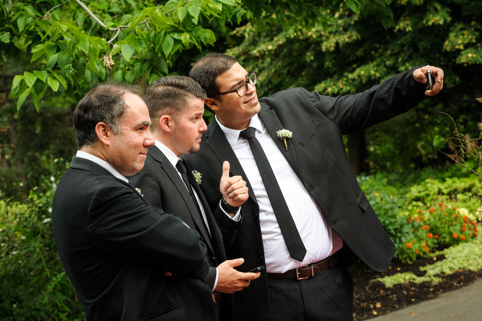 Groomsmen taking selfies at wedding at Parc Jean-Drapeau