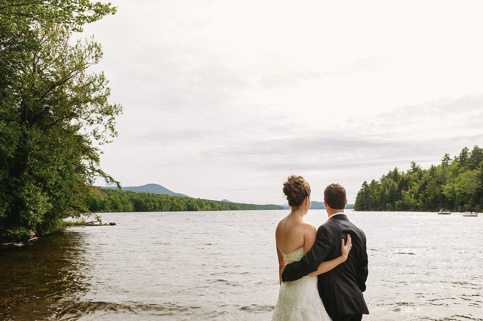 Nouveaux mariés regardant droit devant eux l'étendue d'eau formée par le lac à Magog