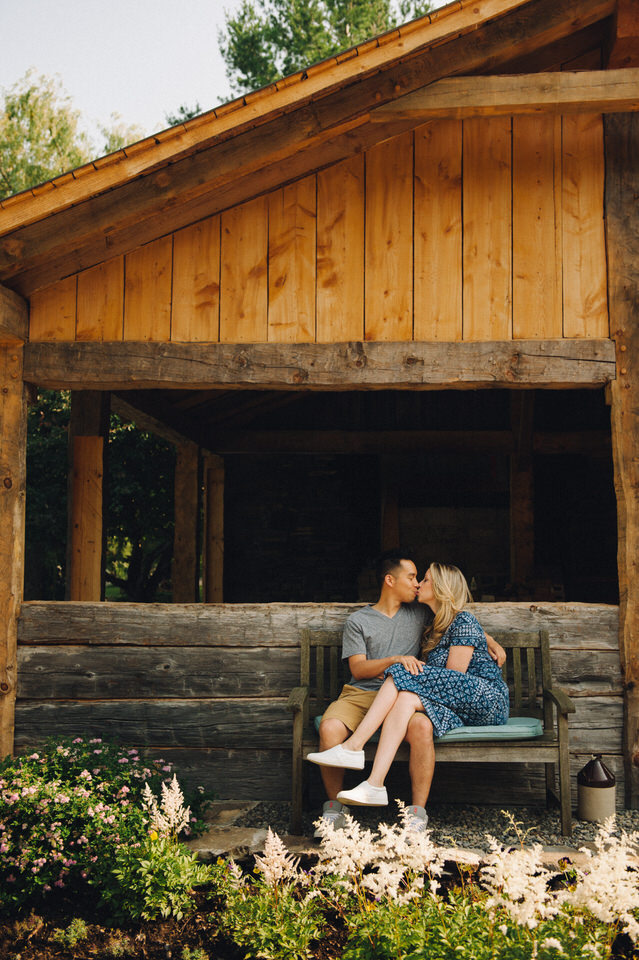 Couple kissing on a wooden bench in a garden