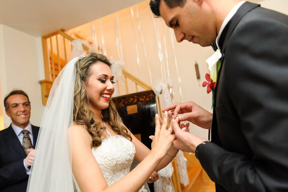 Groom putting ring on bride at her parents' house