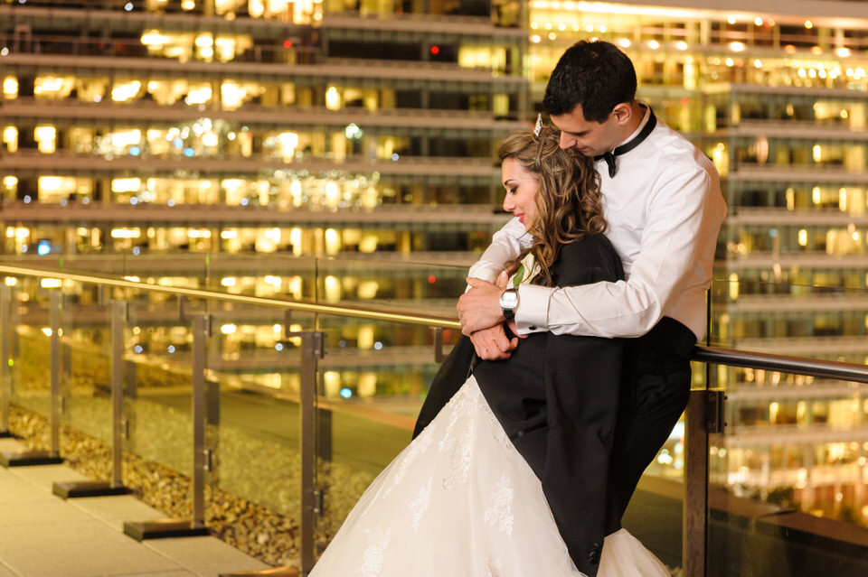 Wedding couple taking a break on the terrace during night time reception