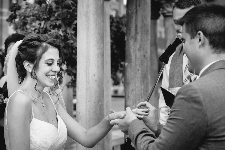 Groom putting ring on bride's finger