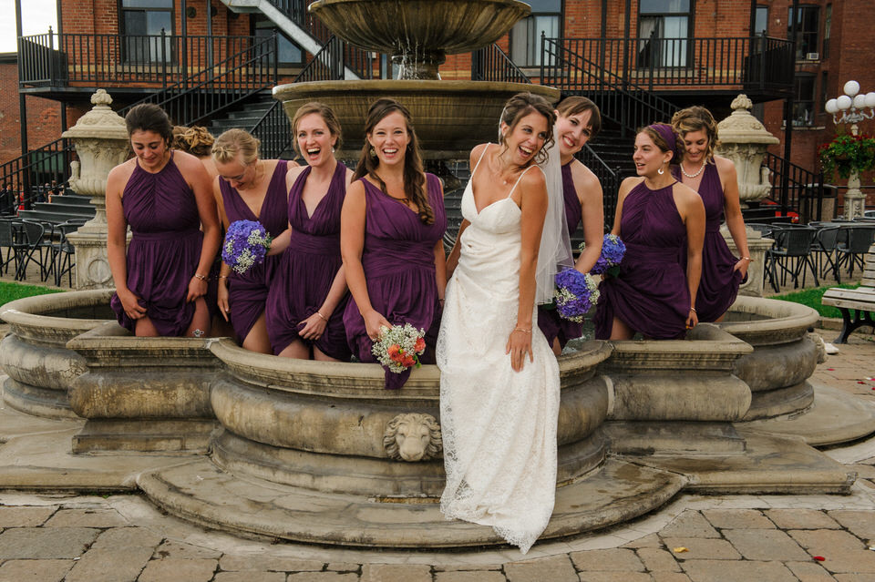 Bridesmaids and bride standing in a fountain