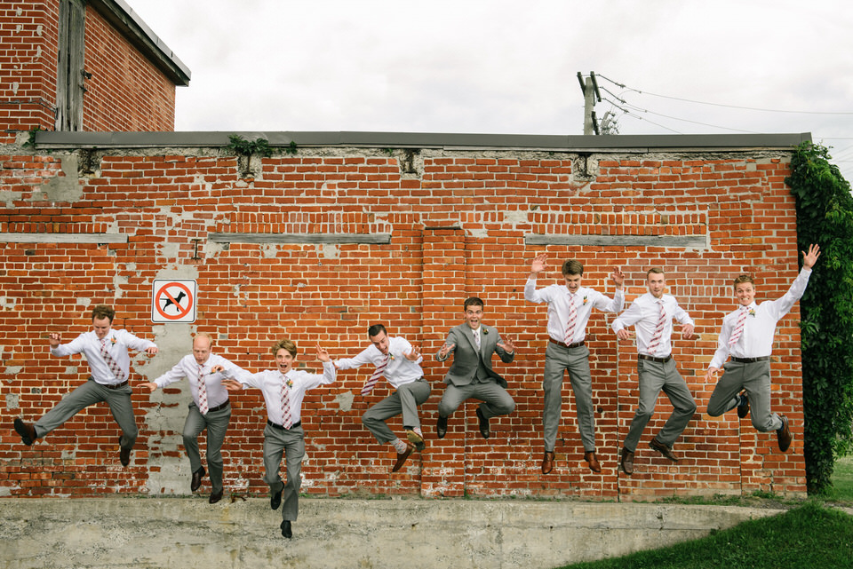 Groomsmen jumping off a wall