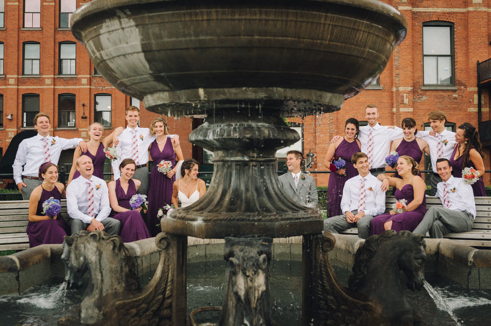 Wedding party portrait framed by a fountain