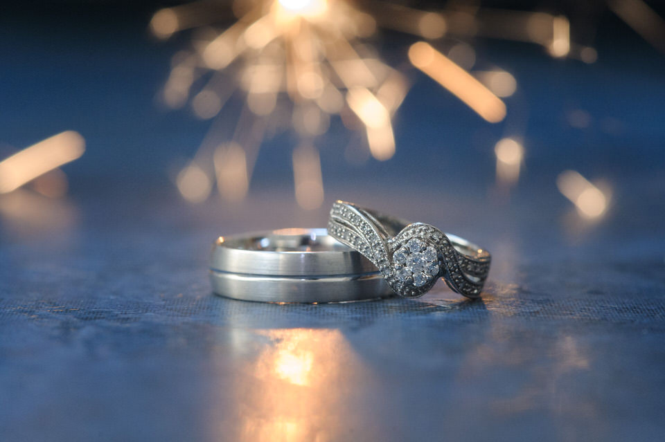 Les anneaux de mariages avec un feu de bengal derrière