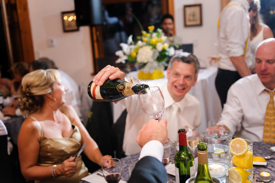 Le papa verse du vin pour quelqu'un pendant le repas de noces