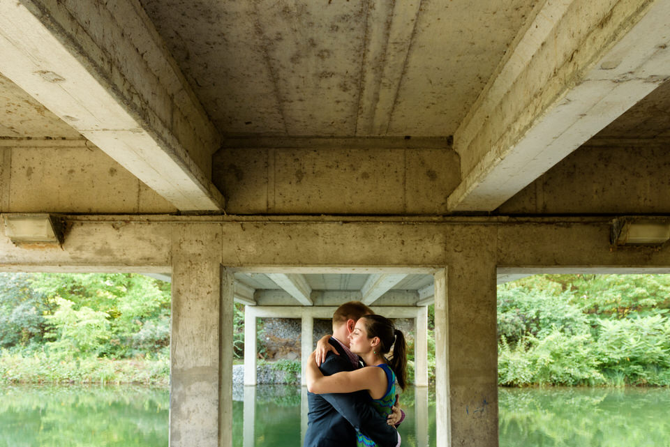 Couple entrelacé près d'un ruisseau en dessous d'un pont du parc Jean Drapeau