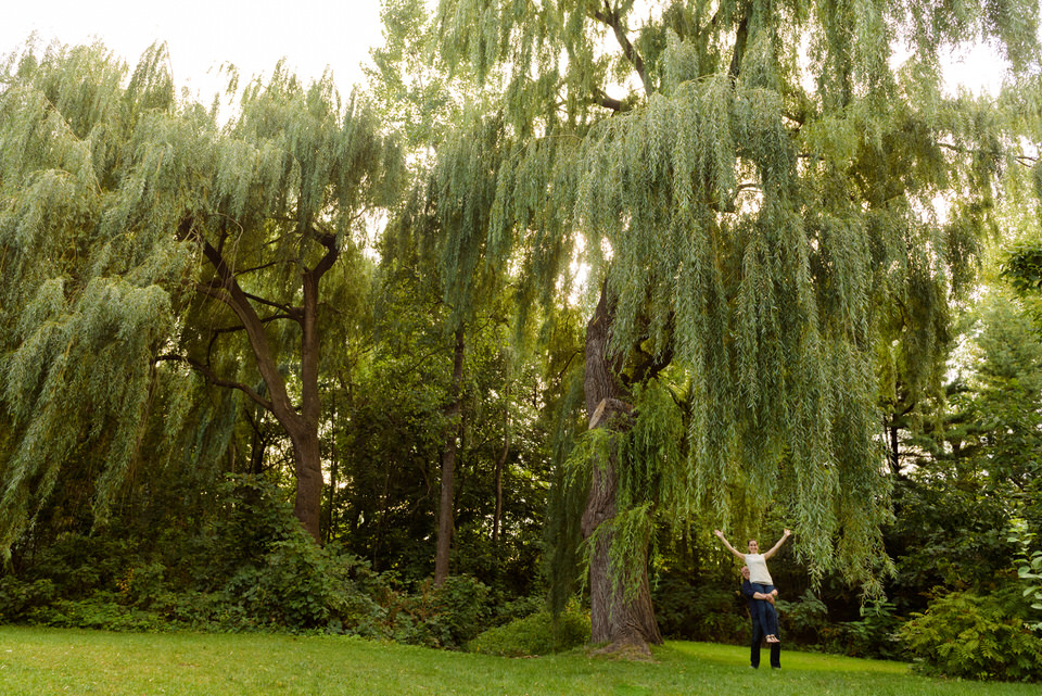 Fiancé portant sa dulcinée pour qu'elle puisse toucher les branches d'un saule pleureur au parc Jean Drapeau