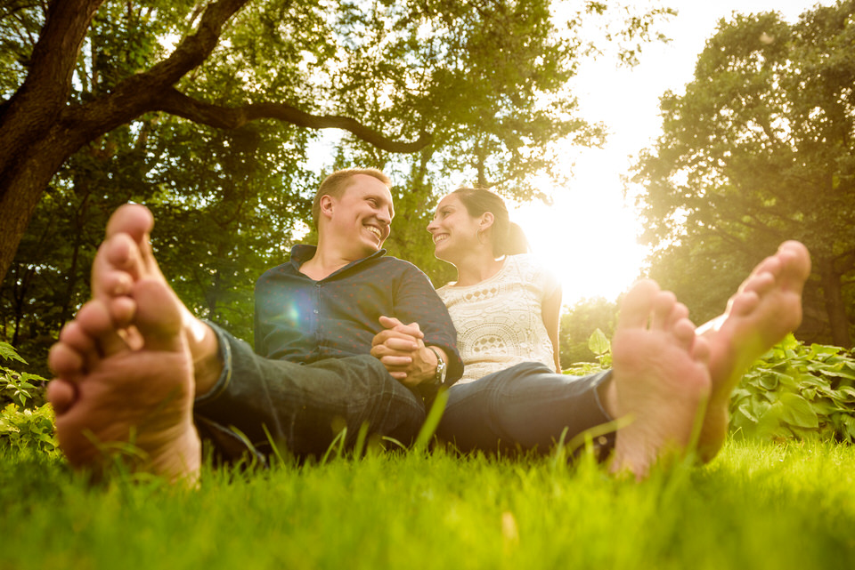 Couple se tenant par la main alors qu'ils sont assis dans un champ de verdure au parc Jean Drapeau