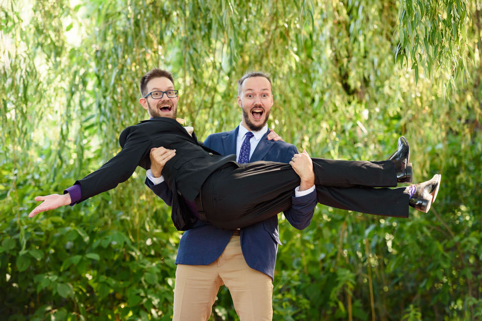 Silly photo with groomsman lifting groom