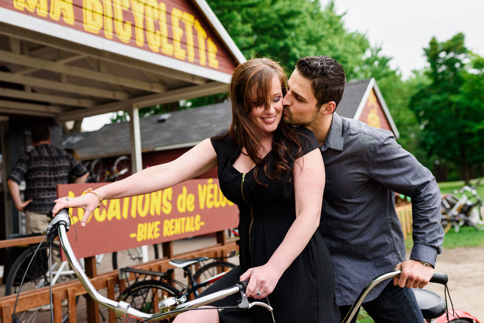 Couple kissing as they hold bike handlebars