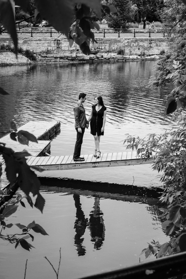 Couple standing on a dock with their reflection in the water of Lachine Canal