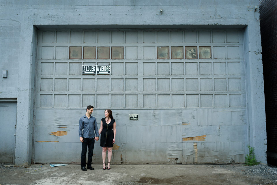 Engagement photo in front of grungy garage doors in Griffintown
