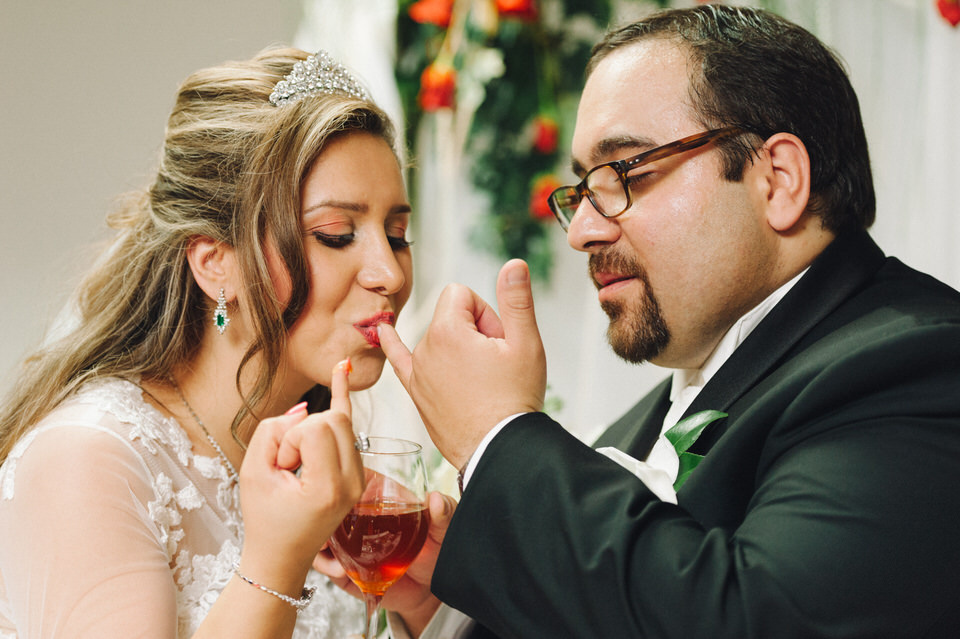 Groom and bride feed each other honey to symbolize sweetness of life