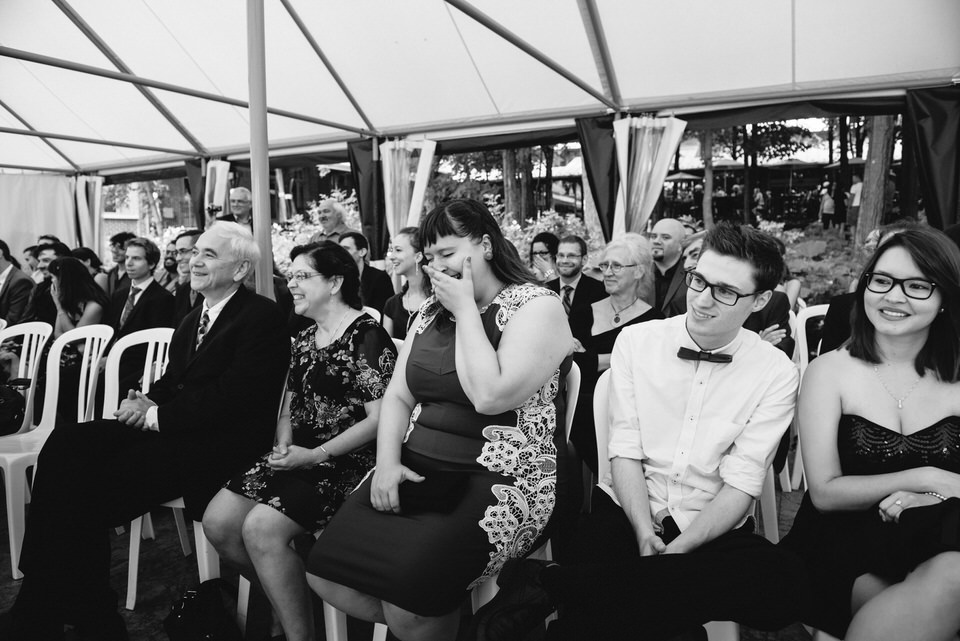 Guests laughing at wedding under tent