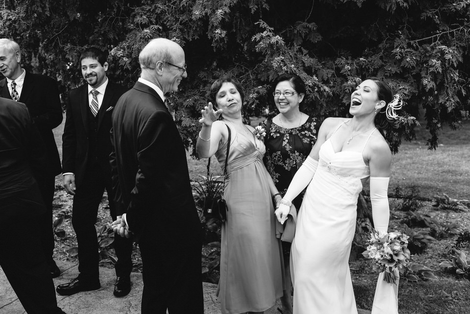 Wedding guests congratulating and laughing with bride