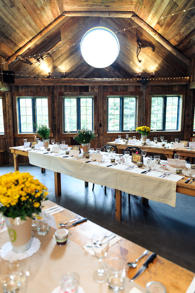 Tables longues installés pour un diner de mariage à l'intérieur de la Cabane à Sucre Haut-Bois Normand