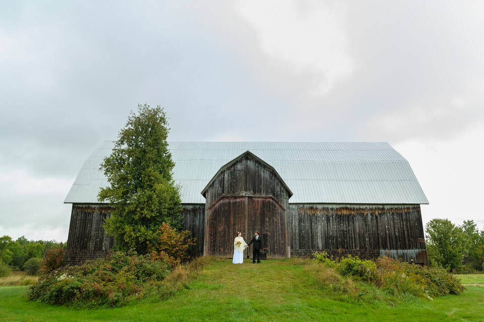 Couple standing in front of barn