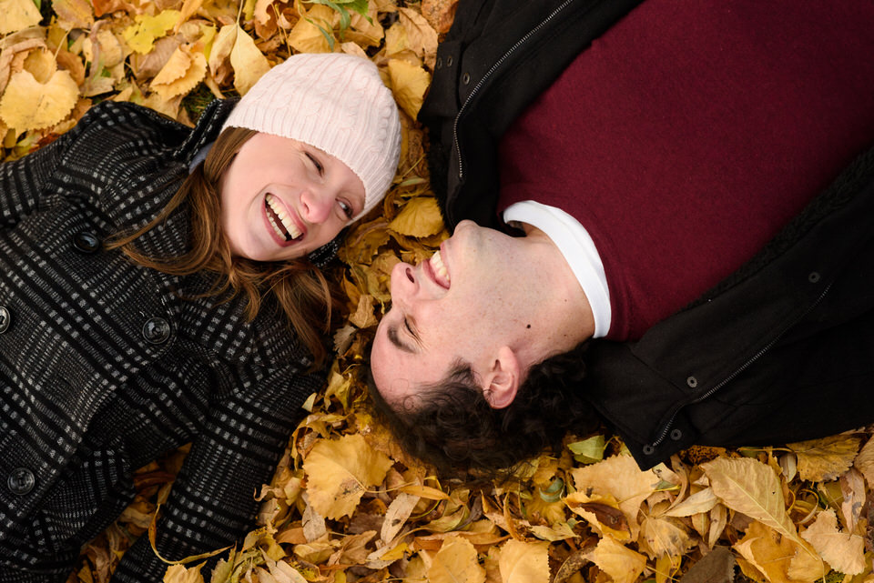 couple lying in a bed of fallen leaves
