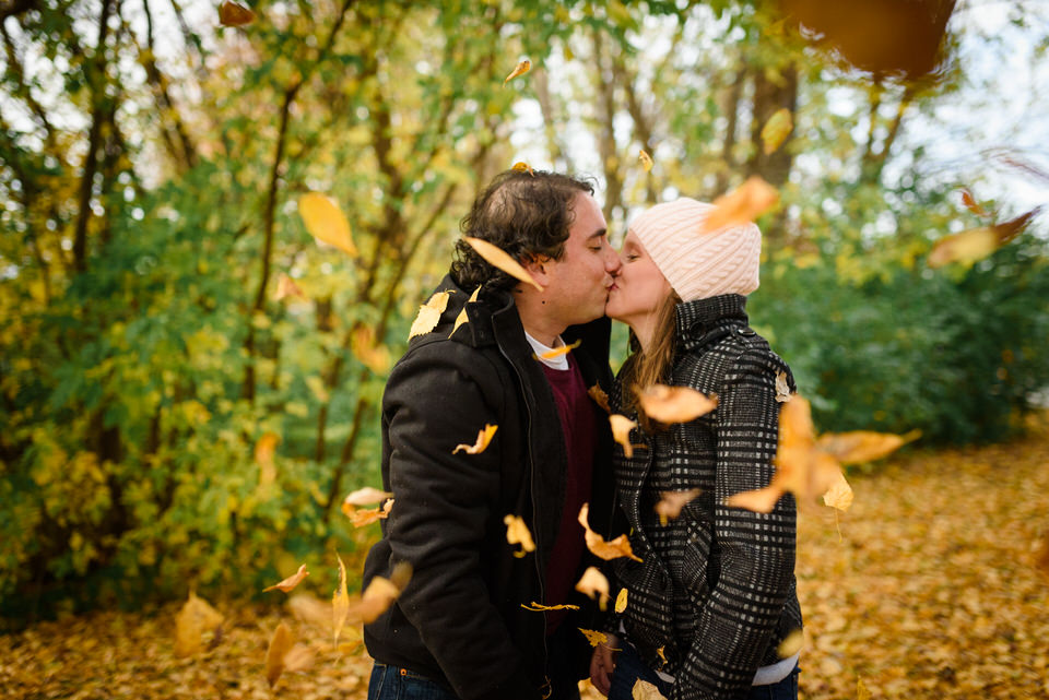 Couple kissing surrounded by dead leaves