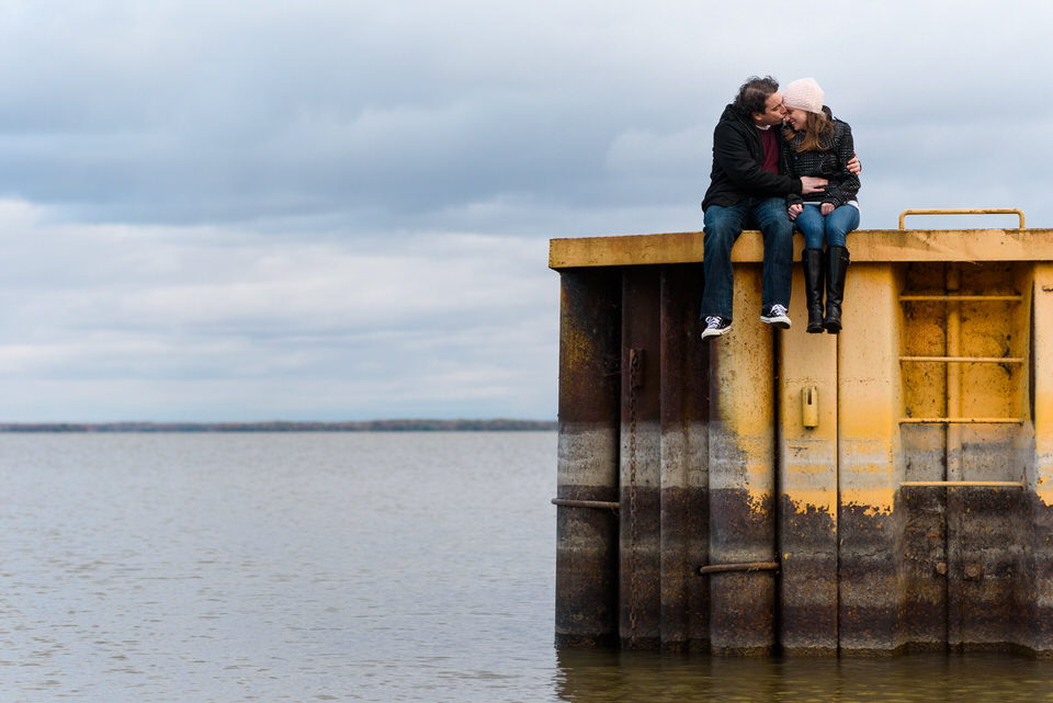 Engaged couple sitting on a dock