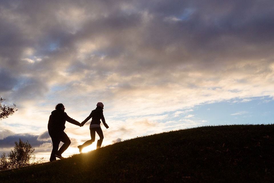 couple going up a hill during sunset