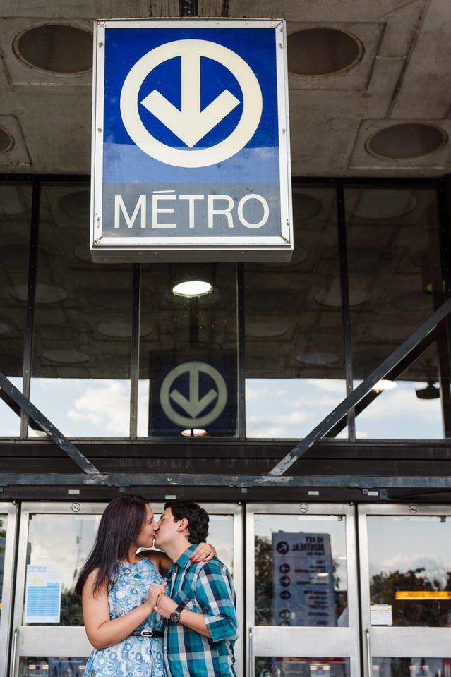 Engaged couple kissing under Montreal Metro sign