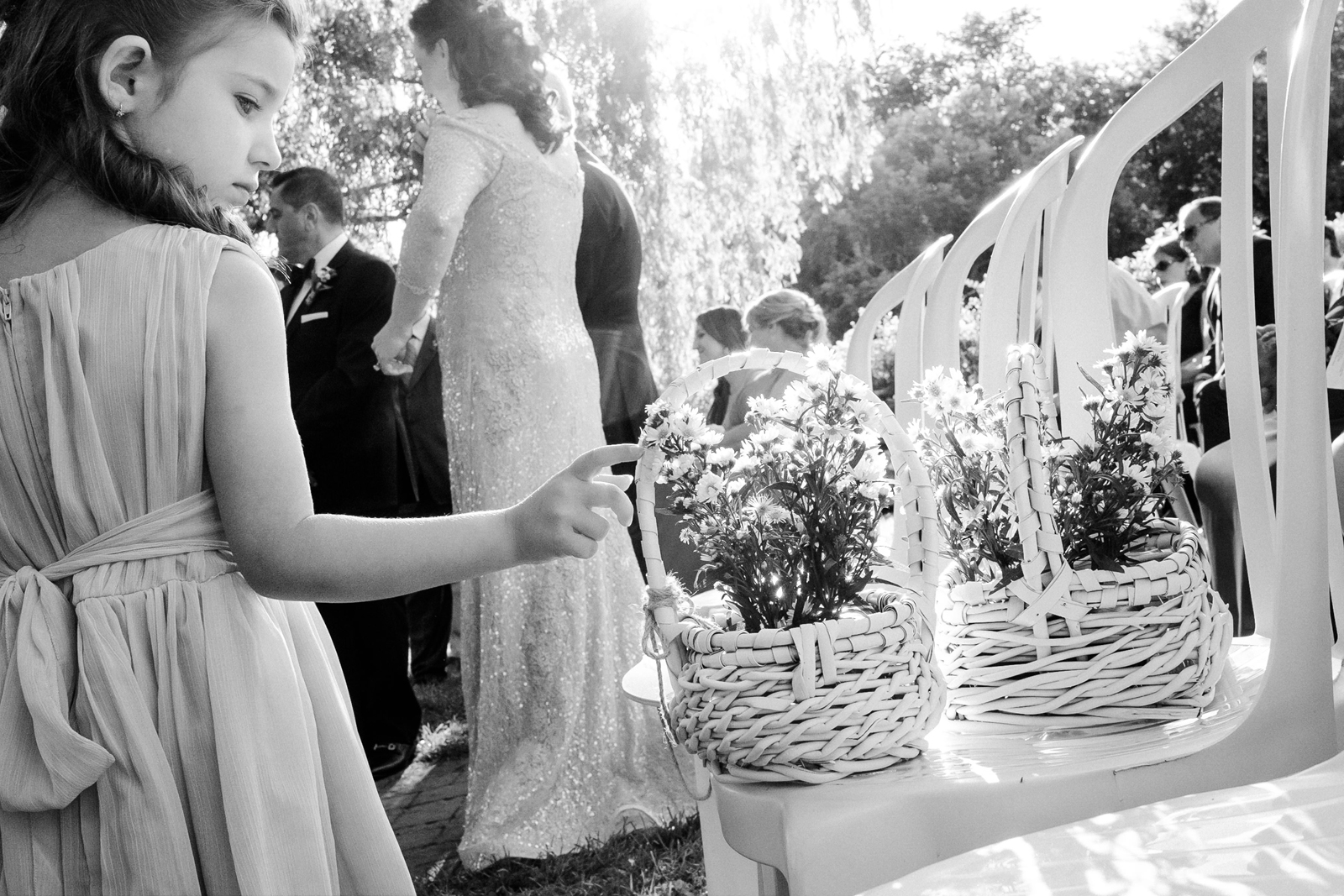 Flower girl curiously touching a flower basket