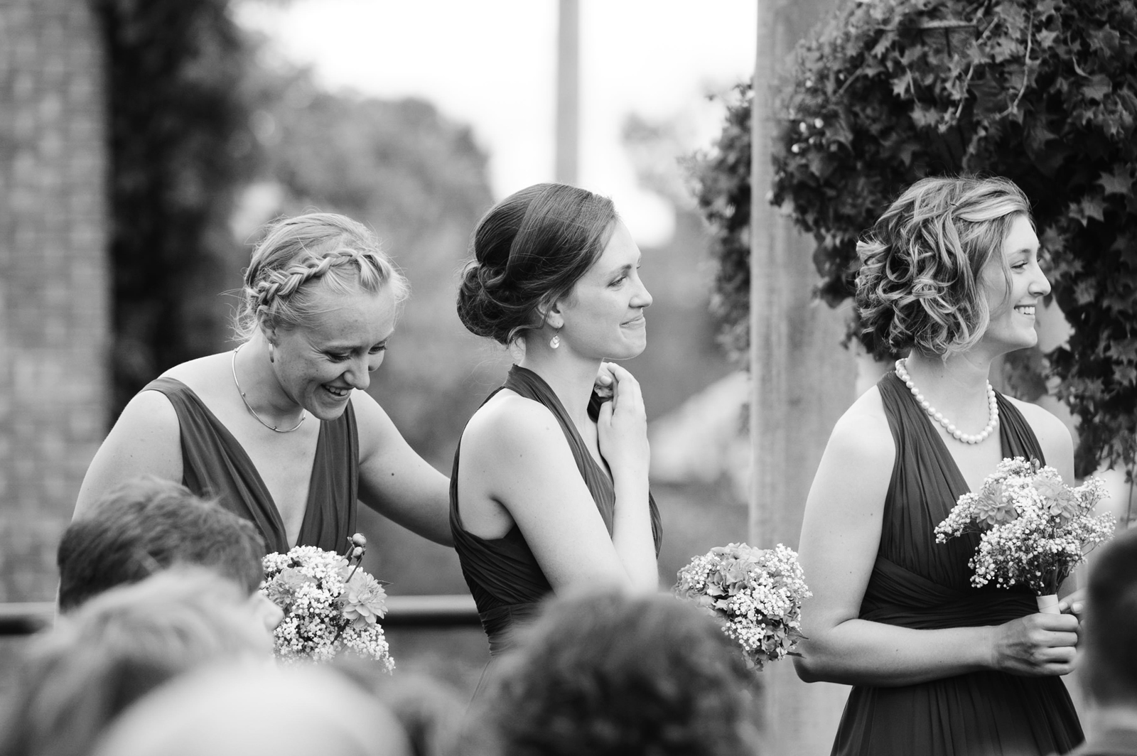 Bridesmaids holding hands and laughing at the ceremony