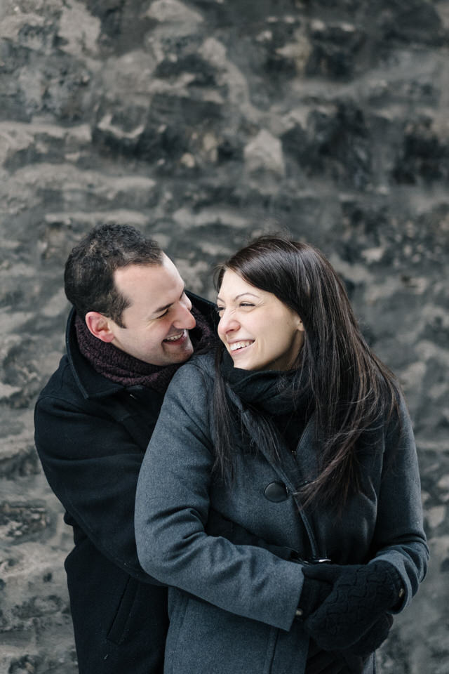 Engaged couple snuggling in winter in old Montreal