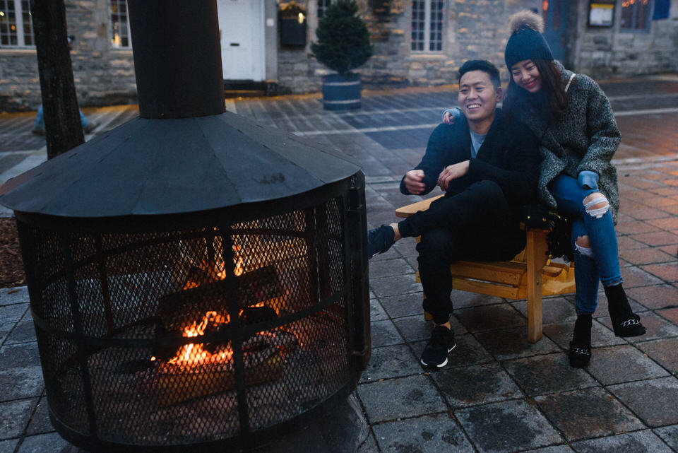 Couple sitting in chair near outdoor fire pit in Montreal