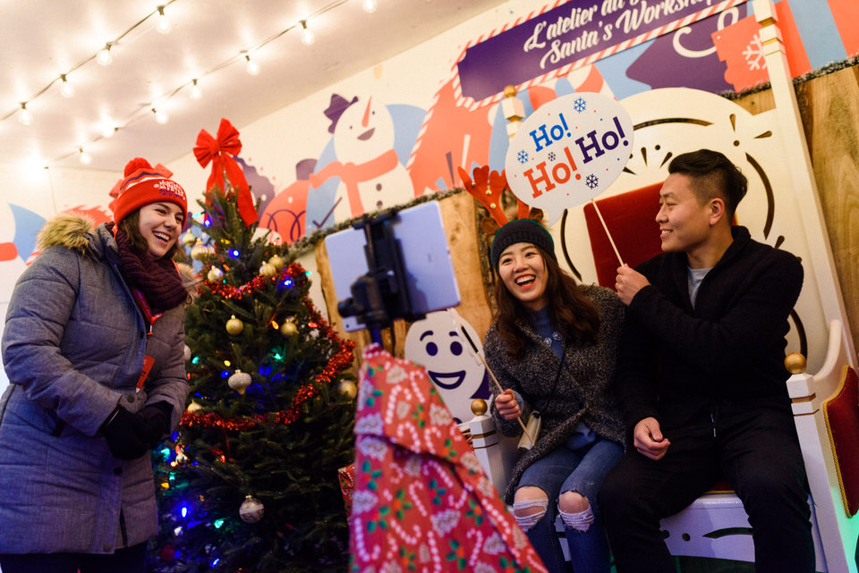 Couple trying a photobooth at Marche de Noel