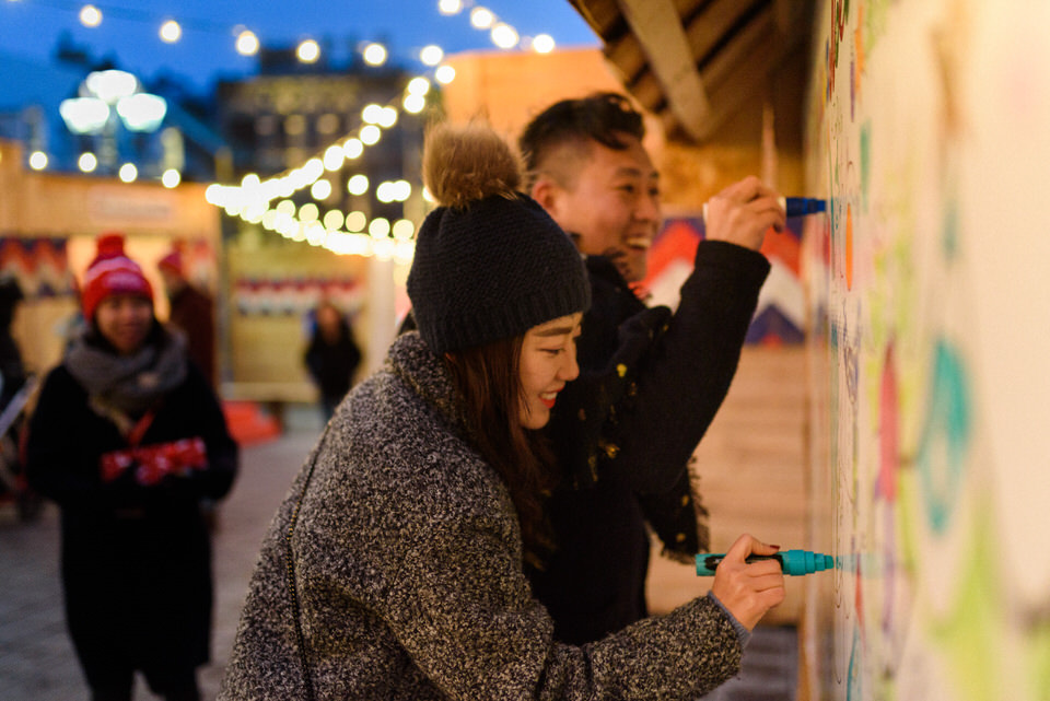 Couple leaving a message on a outdoor message board in Old Montreal