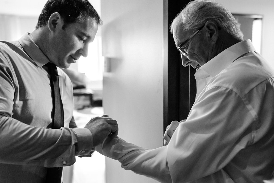 Man doing up cuffs of older man