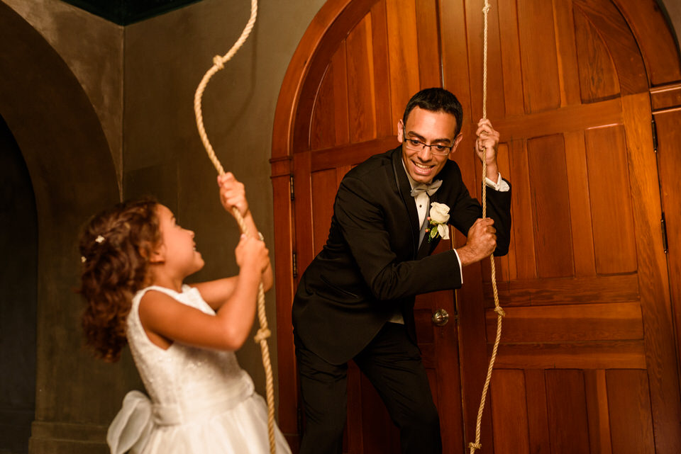 Groom ringing the chapel bell at Abbaye Oka with his daughter