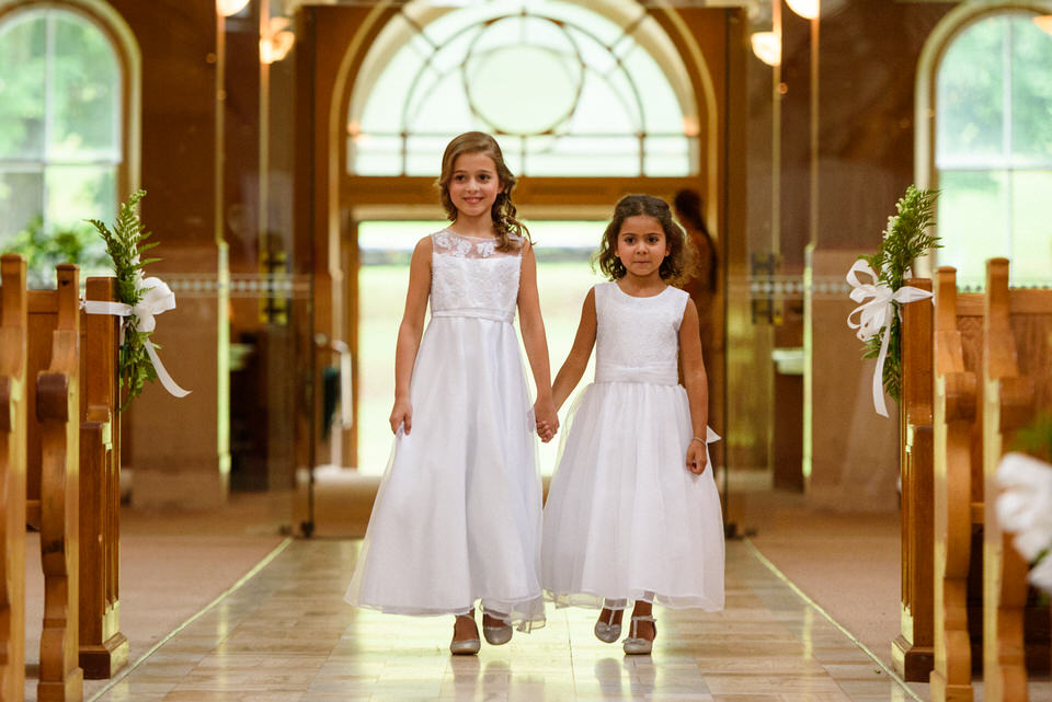 Bride and groom's daughters walking down the aisle at Abbaye d'Oka wedding