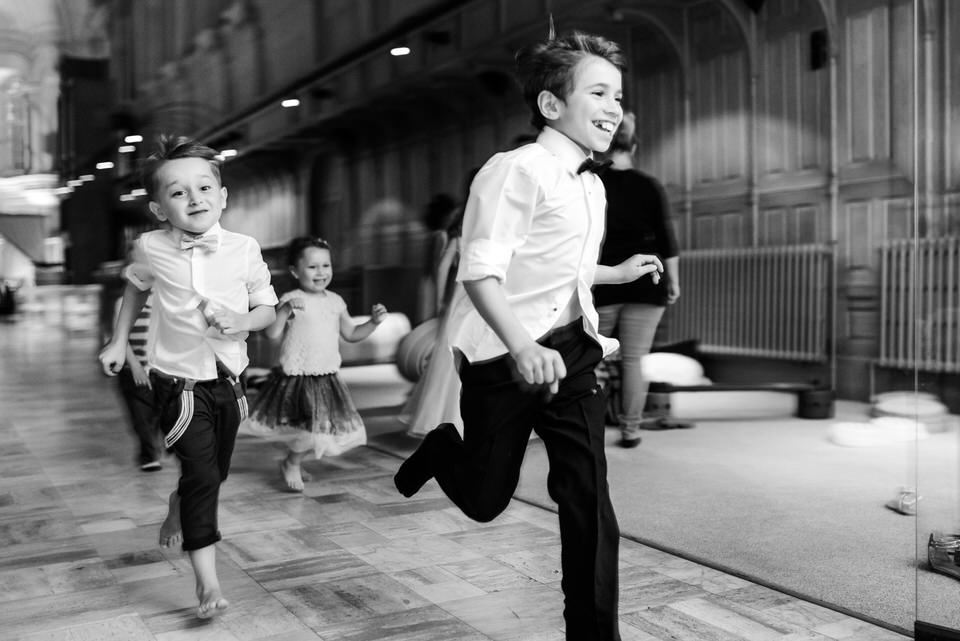 Black and white candid photo of children running at Abbaye Oka wedding