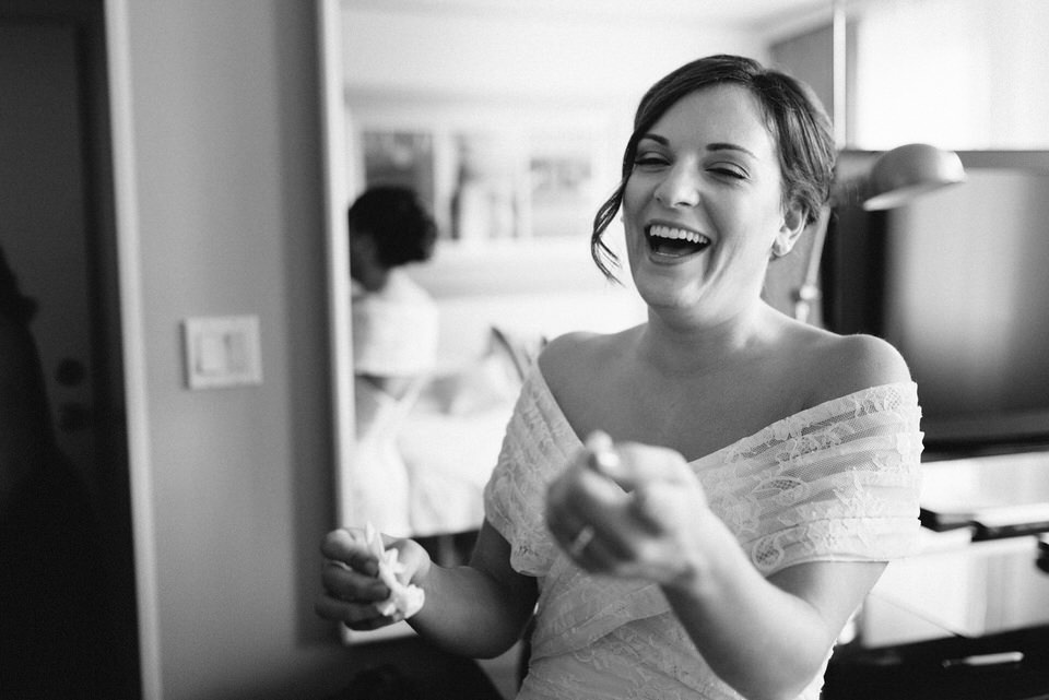 Bride laughing with friend in hotel room