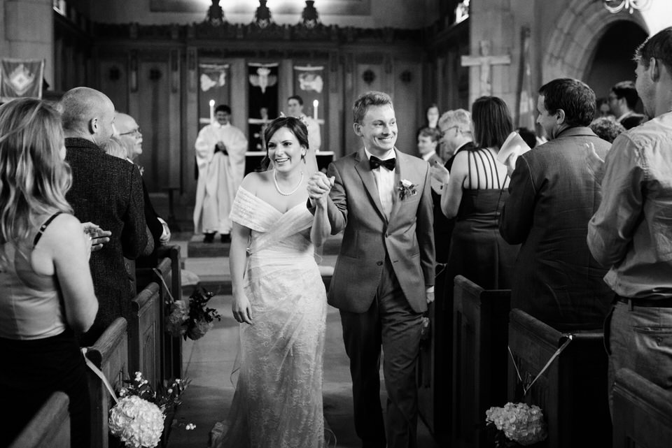 Married couple hand in hand walking back the aisle 