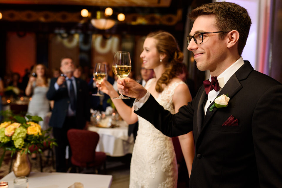 Wedding couple raising glasses in toast
