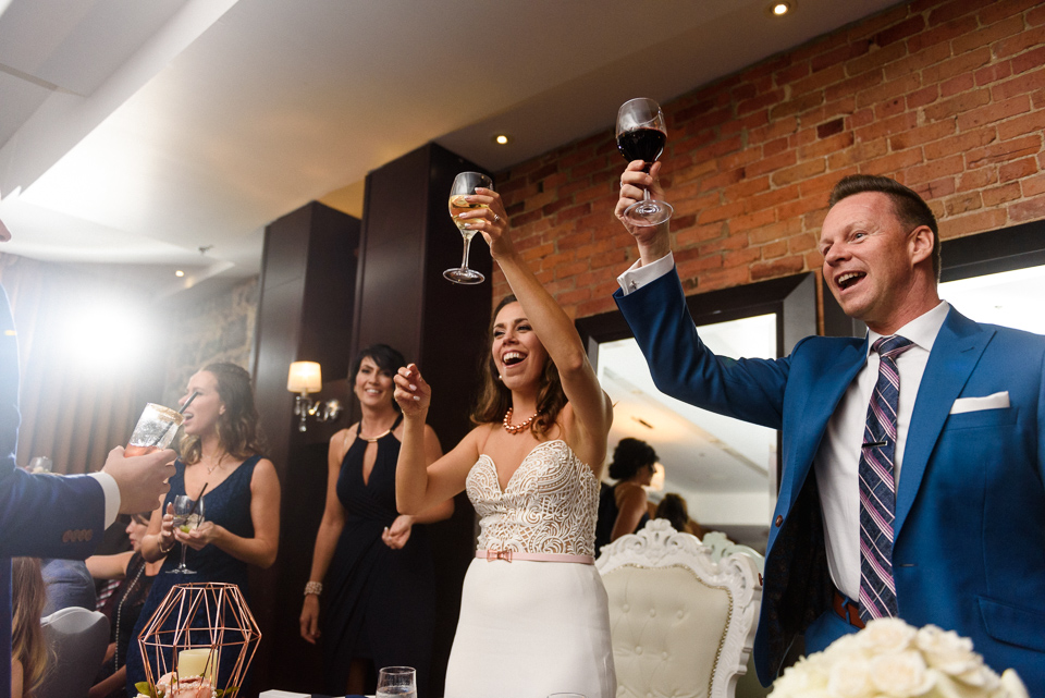 Wedding couple raising glasses in toast