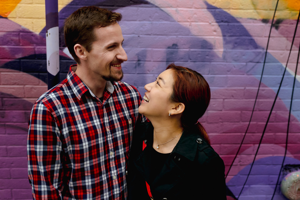 Documentary couple photos near mural in Mile-End Montreal