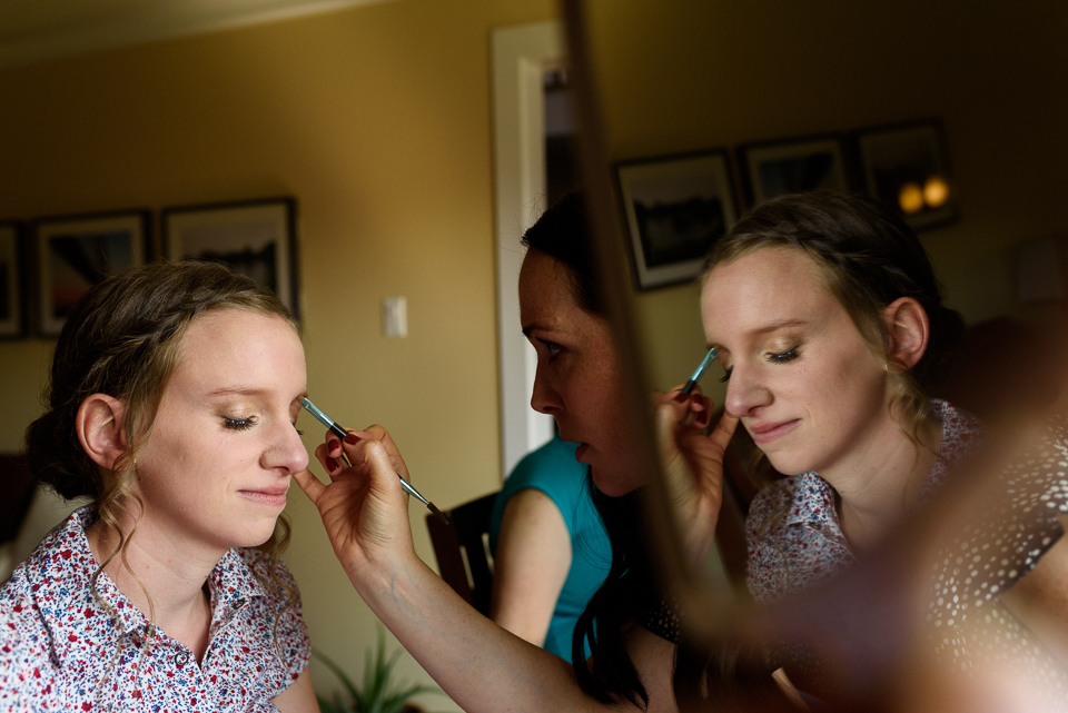 Reflection photo of bride getting makeup done