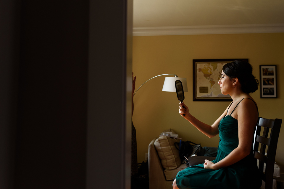 Bridesmaid checking make up in hand mirror